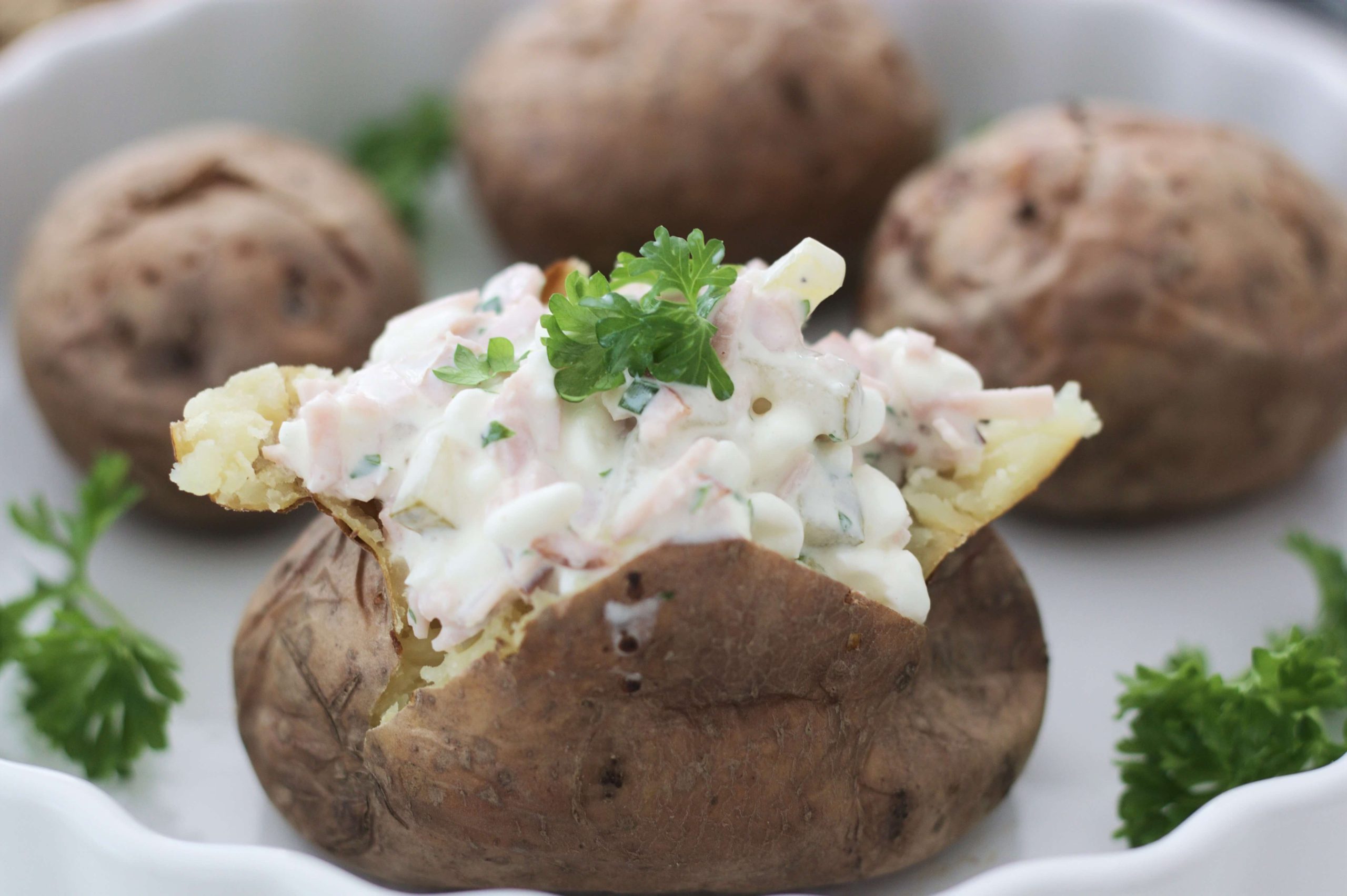 Kinkkutäytteellä täytetty uuniperuna ja persiljaa